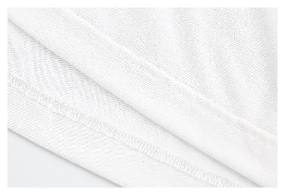 Close-up of the white shirt's folded hem and overlocked stitching.
