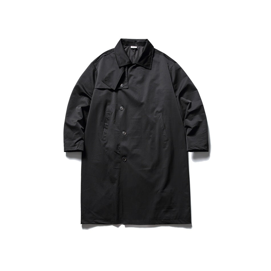 Black long trench-style coat flat lay with notched collar, chest flap, button front and long sleeves