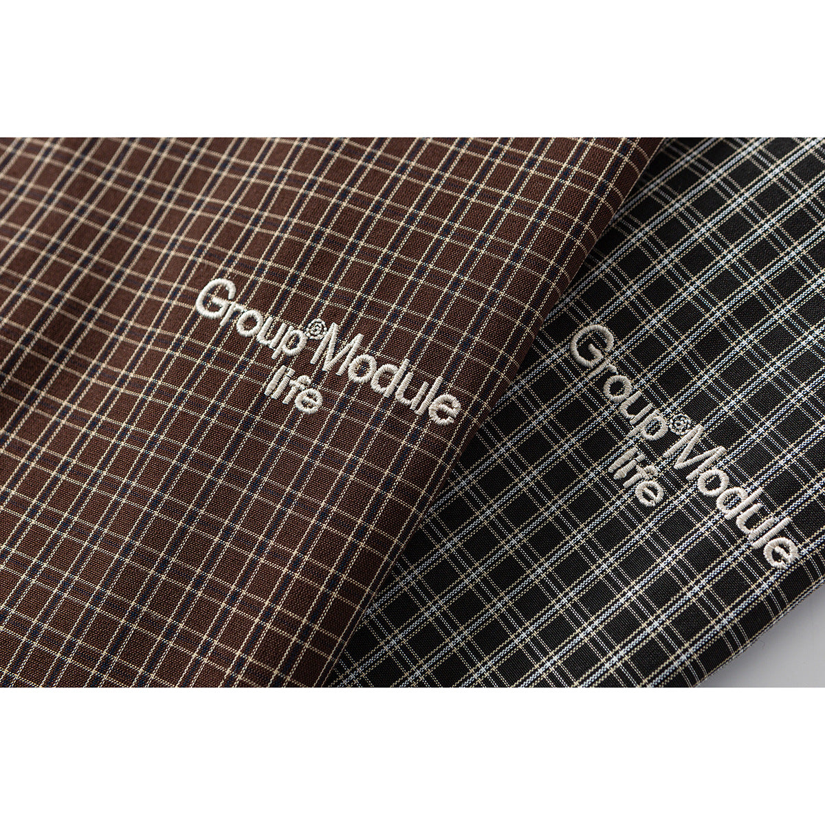 White embroidered lettering on brown and black plaid shirt fabric.
