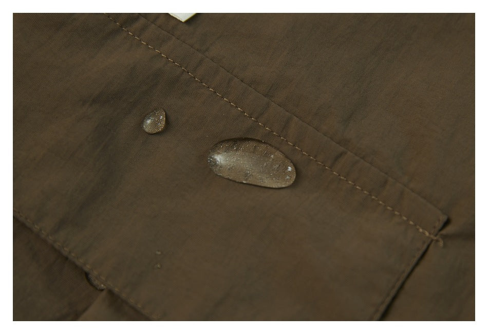 Water droplets on brown shorts fabric in a close-up view.