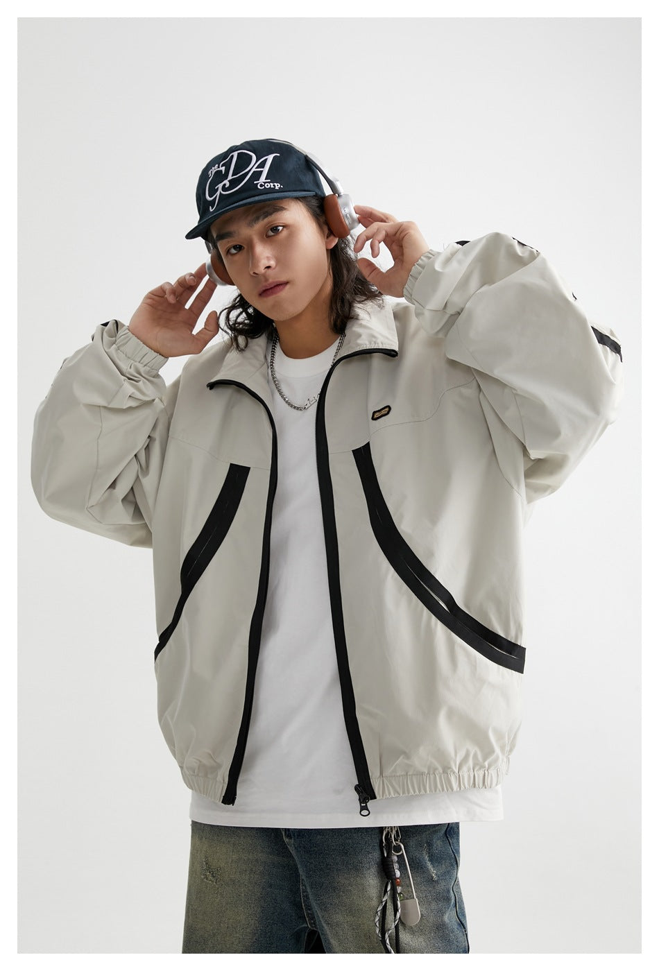 Model wearing the light gray jacket with black trim, shown from the front with its zipper open.