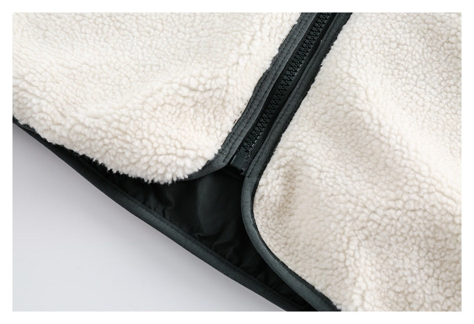 Close-up of a cream sherpa-lined jacket with a black zipper and dark fabric trim.