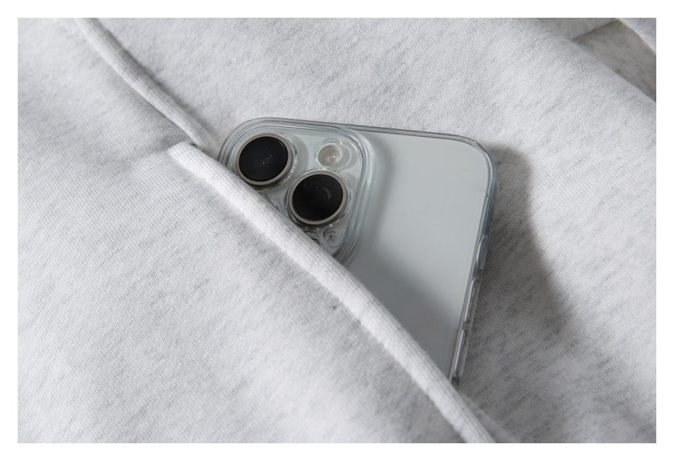 A smartphone partly tucked into the pocket of a light gray hoodie.