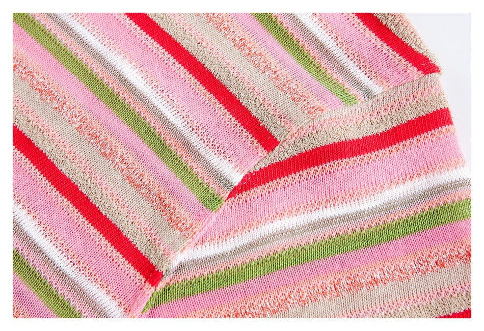 Close-up of the shoulder seam on pink, beige, green, and white striped knit fabric.