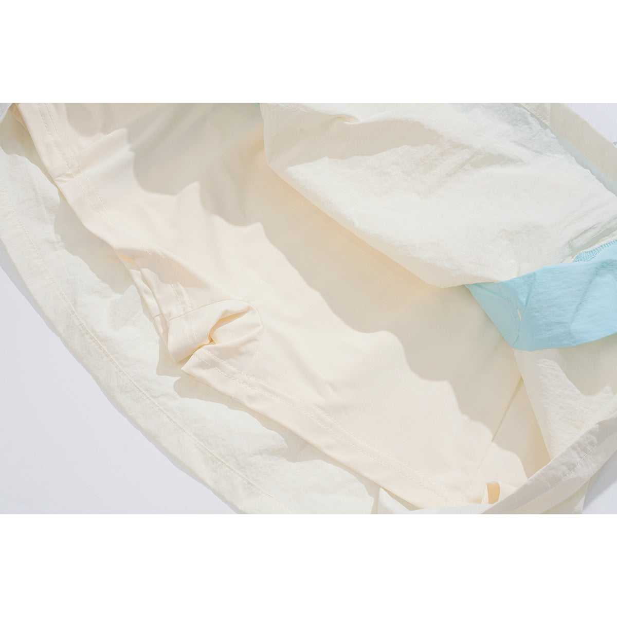 Inside view of an ivory skirt showing its pale blue lining and stitched construction.