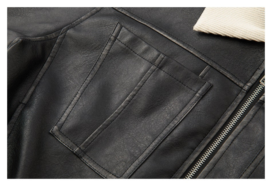 Close-up of a stitched rectangular chest pocket and front zipper on a black jacket.