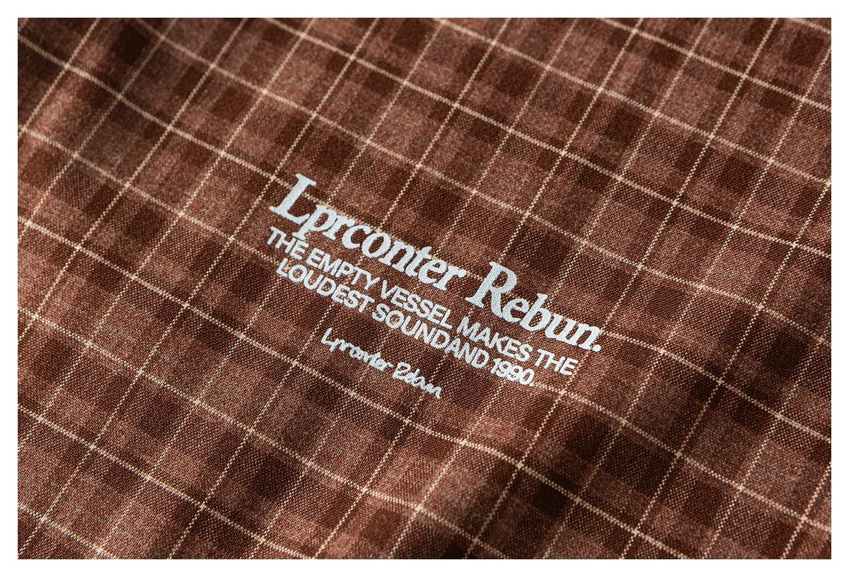 White English lettering printed on brown windowpane-check shirt fabric.