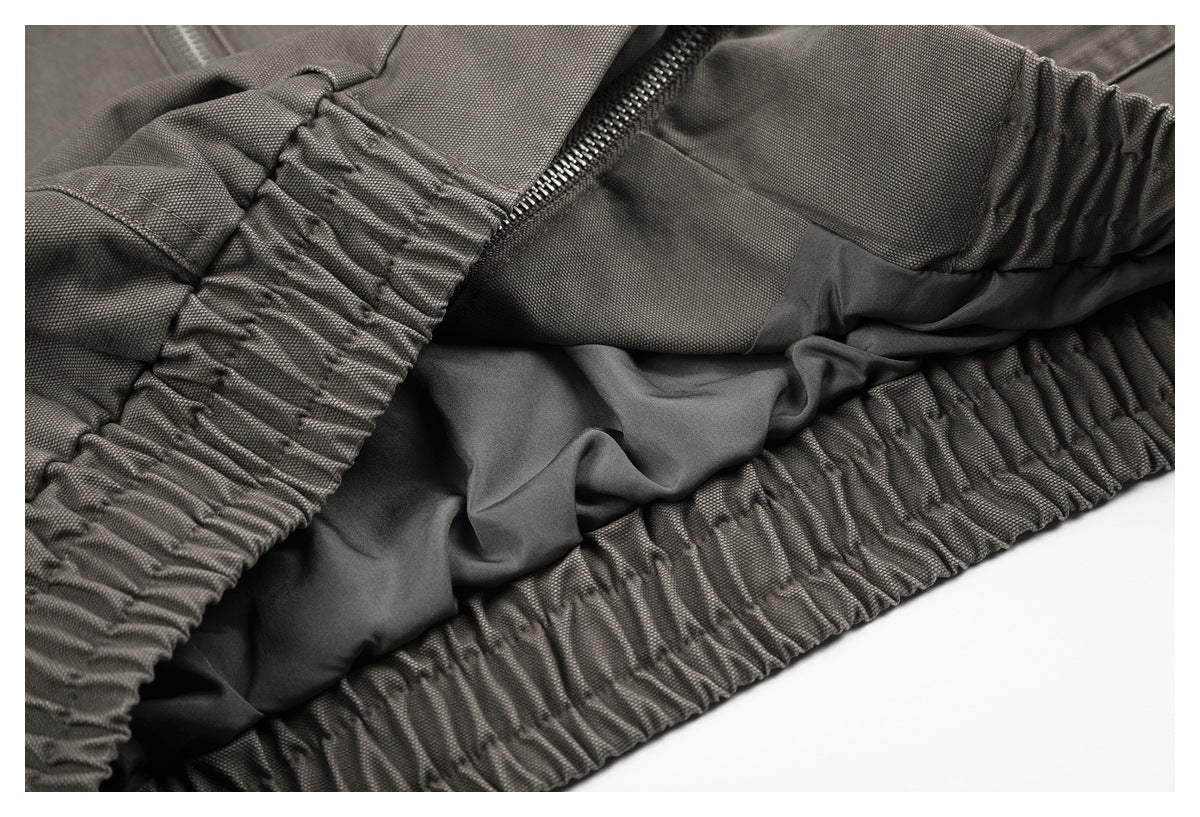Close-up of gathered elastic edging and dark lining inside a charcoal-gray garment.