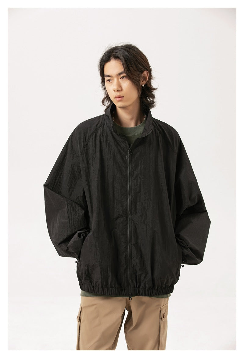 Model wearing a black oversized zip-up jacket with a stand collar and elastic hem.