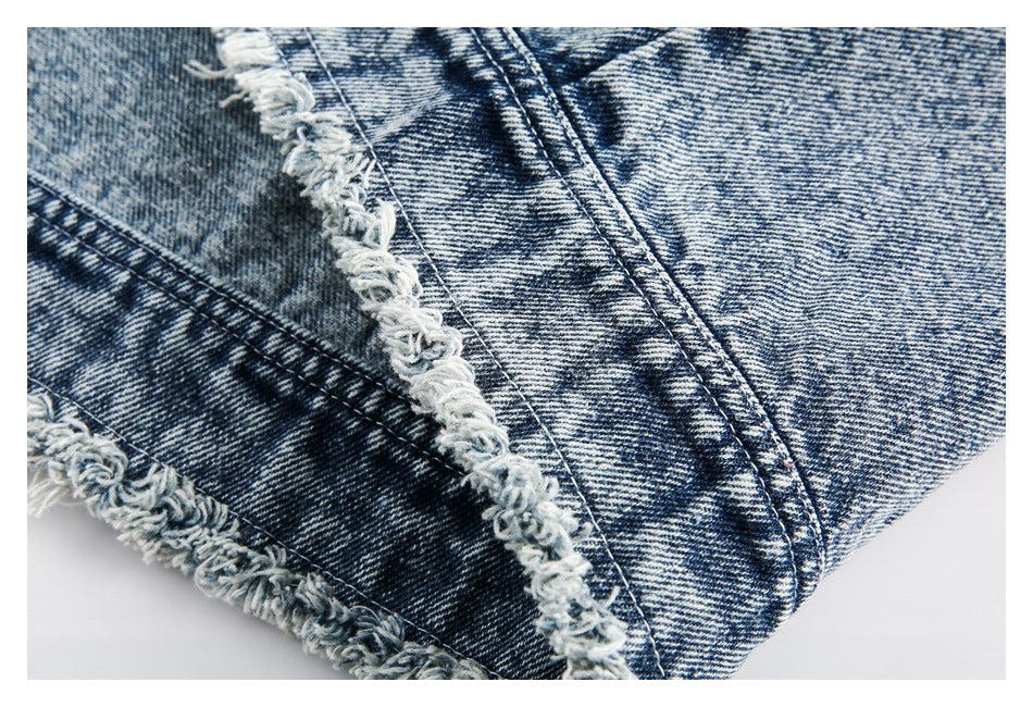 Close-up of blue acid-wash denim seams and thick, frayed raw edges.