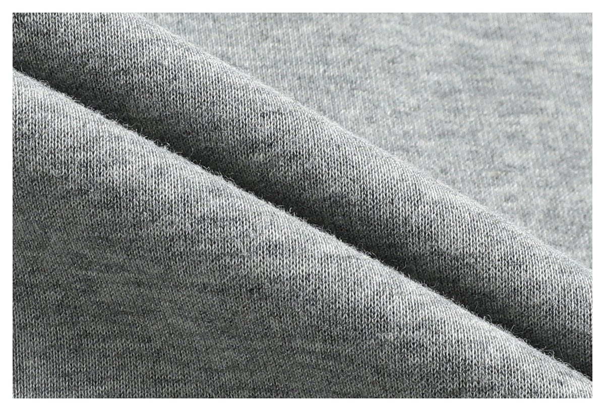 Macro view of the heather-gray sweatshirt fabric, showing its knit texture and folded surface.