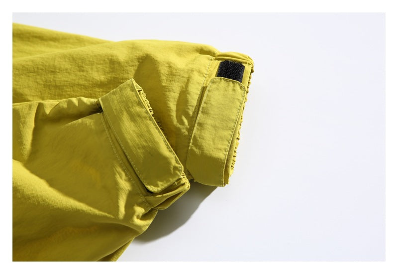 Close-up of a yellow-green jacket sleeve cuff with a black hook-and-loop tab.