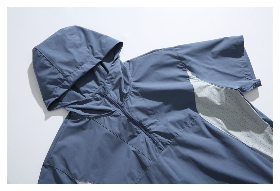 Angled flat lay close-up of a slate-blue short-sleeve hooded pullover with a front zipper and pale perforated side panels.