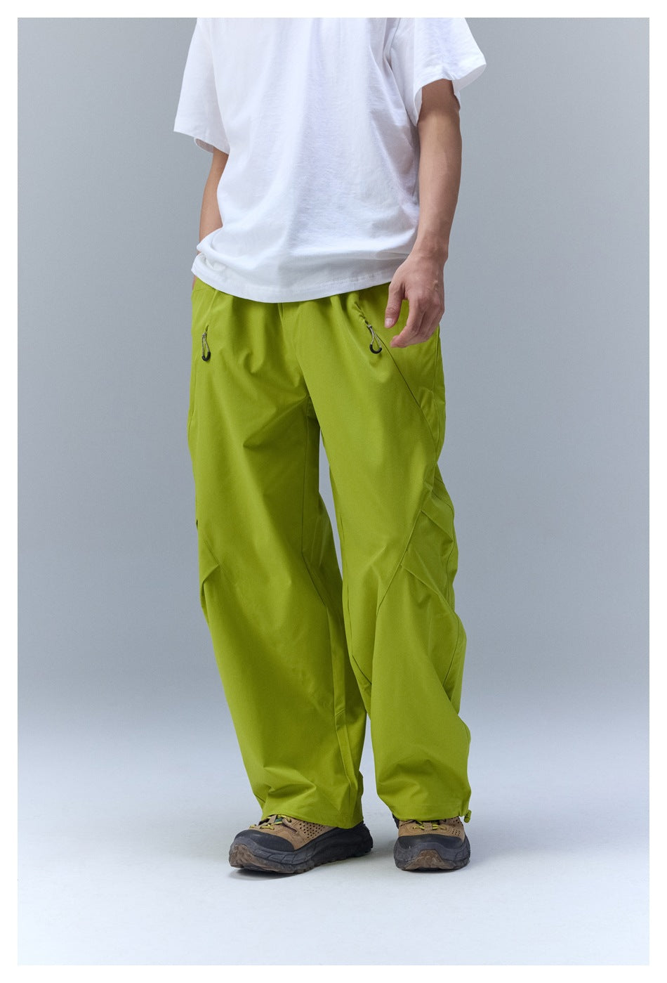 Person wearing yellow-green wide-leg pants with a white T-shirt, angled view showing seams and pleats