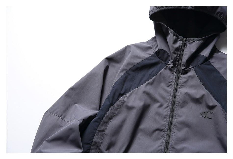Close view of the charcoal-gray jacket's hood, upper front zipper, dark shoulder panels and chest emblem.