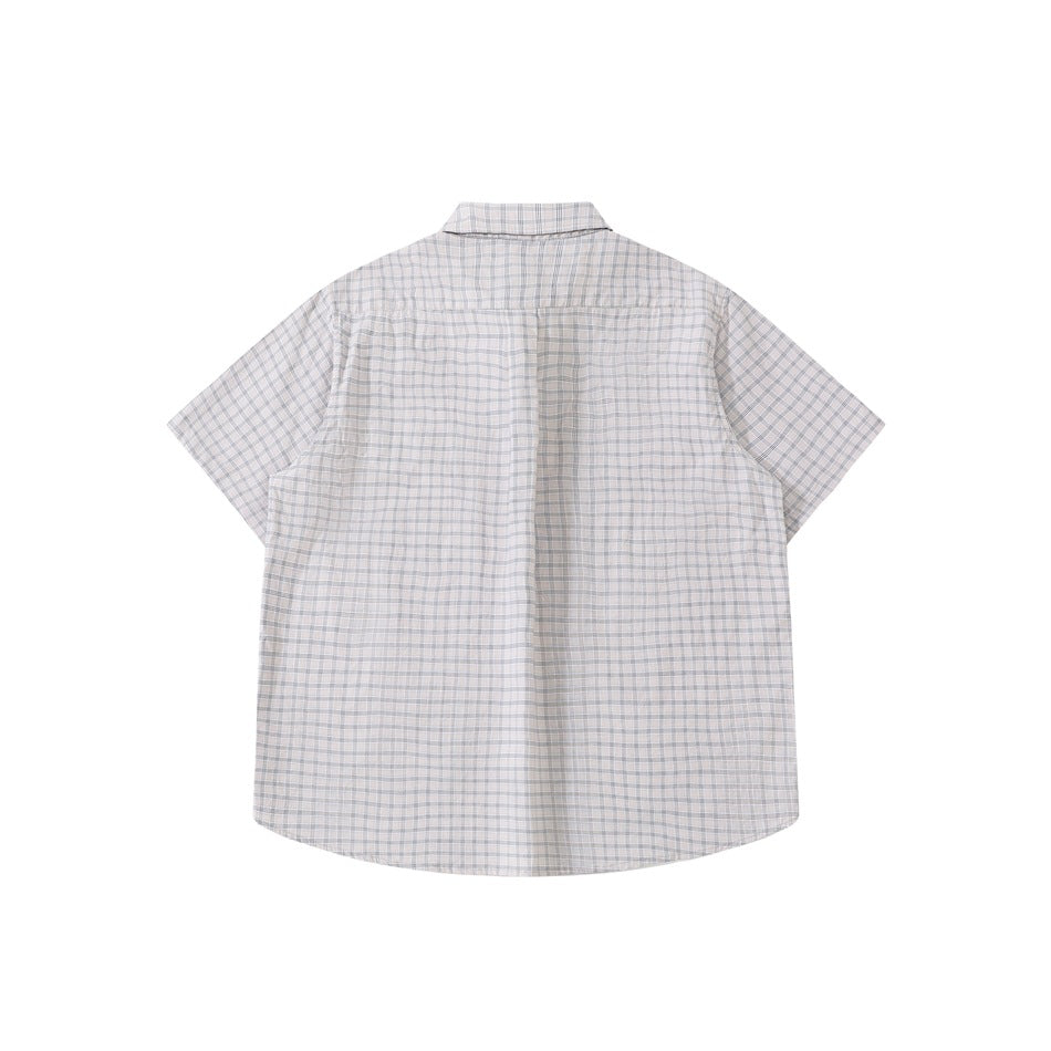 Back view of a grayish-white plaid short-sleeve shirt laid flat, showing back yoke and curved hem
