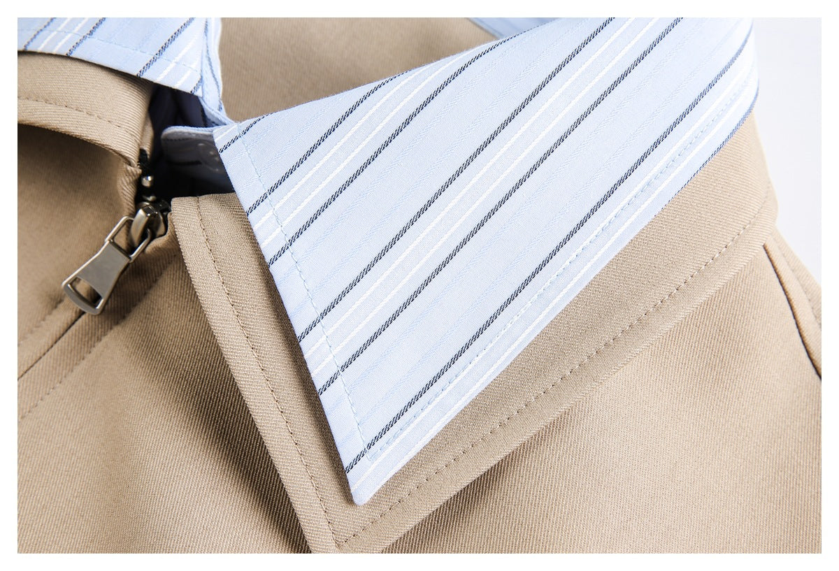Close-up of the beige jacket lapel beside a light blue striped shirt collar and zipper.