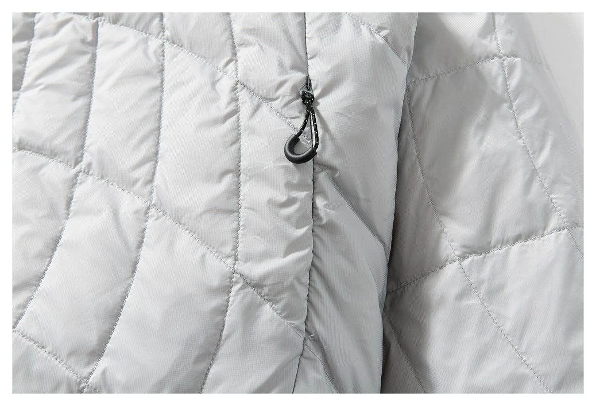 Close-up of light gray quilted jacket panels and a black corded zipper pull.