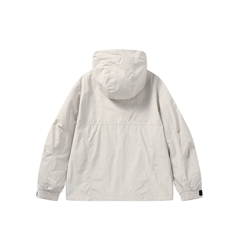 Back view of beige hooded jacket showing paneled seams, elasticated cuffs and cuff tabs