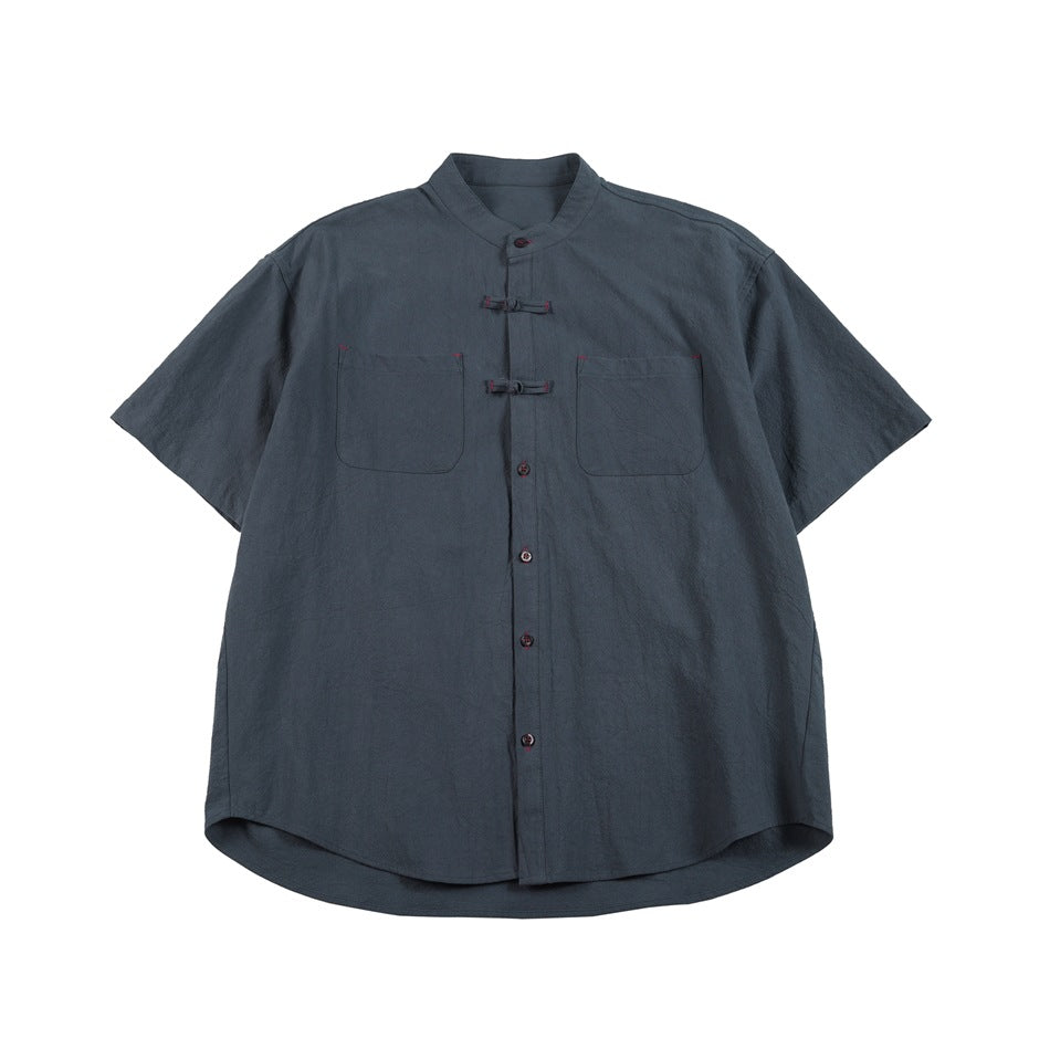 Blue-gray short-sleeve stand-collar shirt with frog closures, buttons and two chest pockets, flat front view
