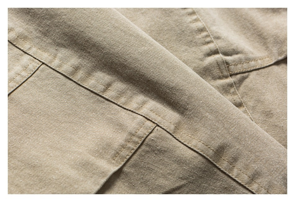 Close-up of taupe-beige garment panels with intersecting stitched seams.