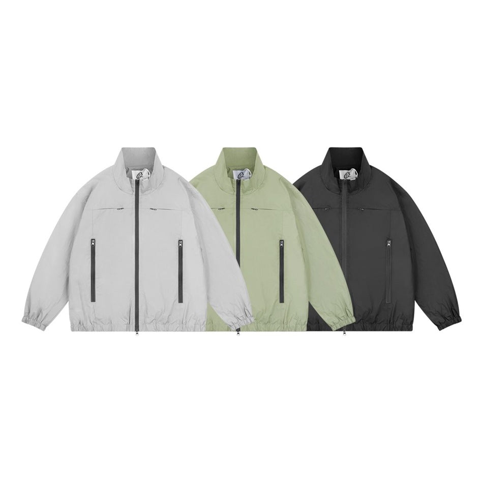Three front views of a stand-collar zip jacket in light gray, pale sage green, and black.