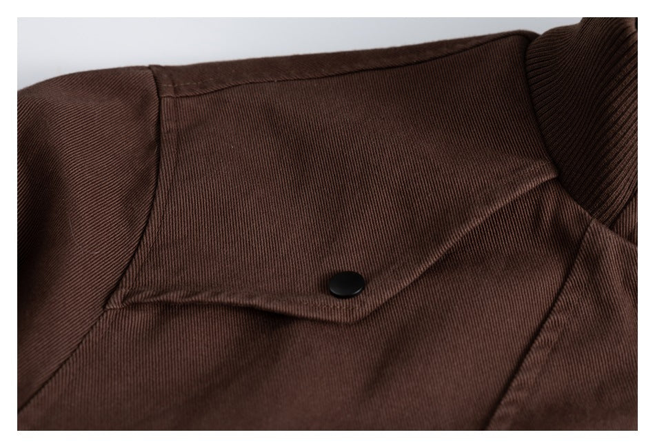 Close-up of a dark brown jacket panel with a buttoned flap and ribbed collar edge.