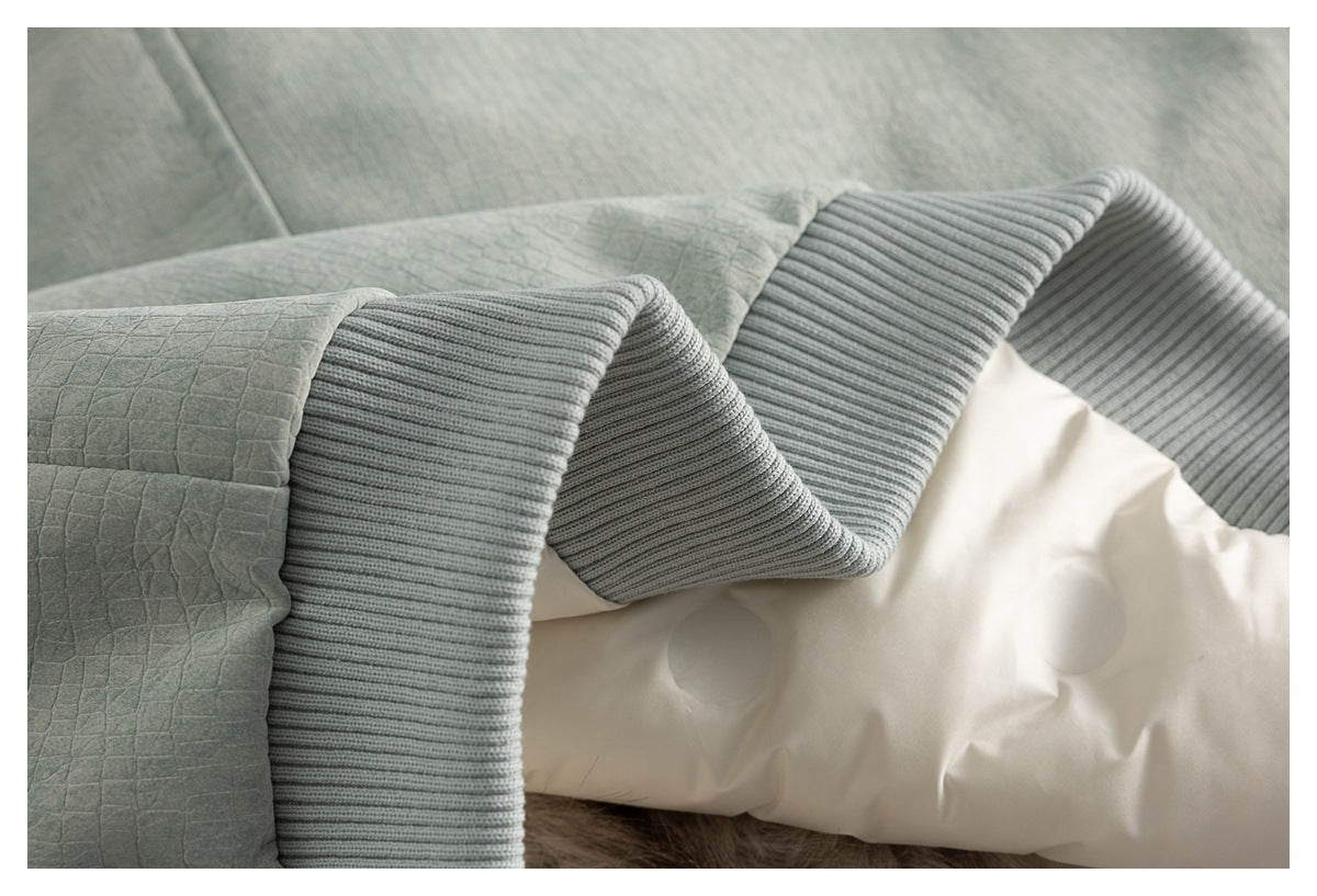 Close-up of gray quilted fabric beside a wide ribbed edge and white padded material.