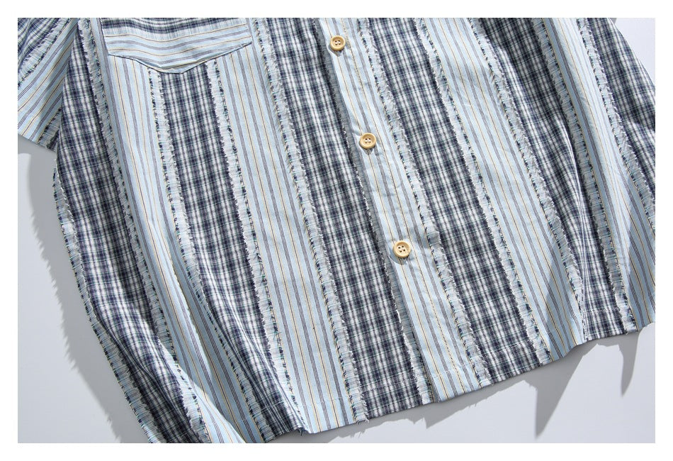 Close-up of the shirt’s front hem and button placket, with alternating plaid and fine stripe panels.