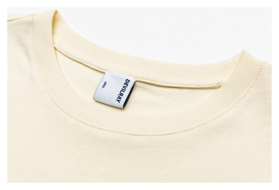 Close-up of an ivory T-shirt crew neck, stitching and sewn-in DEVILRAY label.