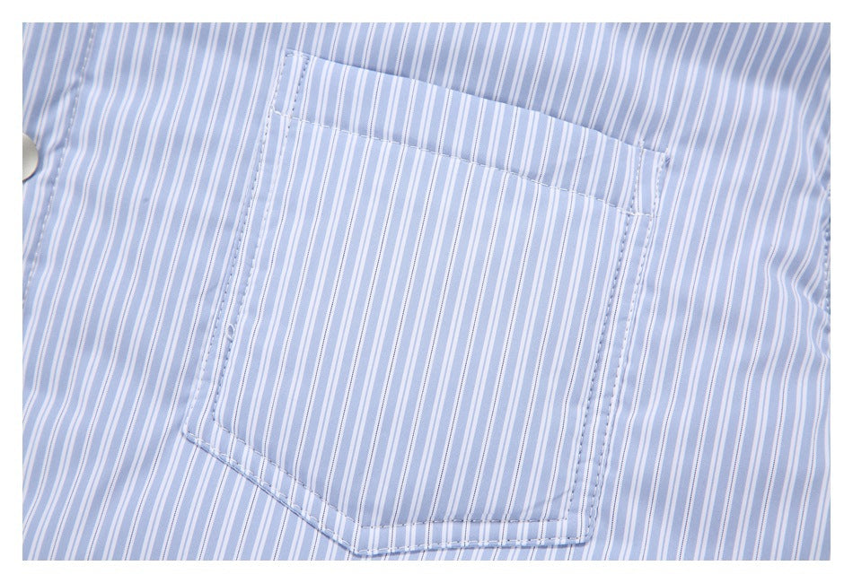 Close-up of a rectangular chest pocket on a pale blue and white striped shirt.