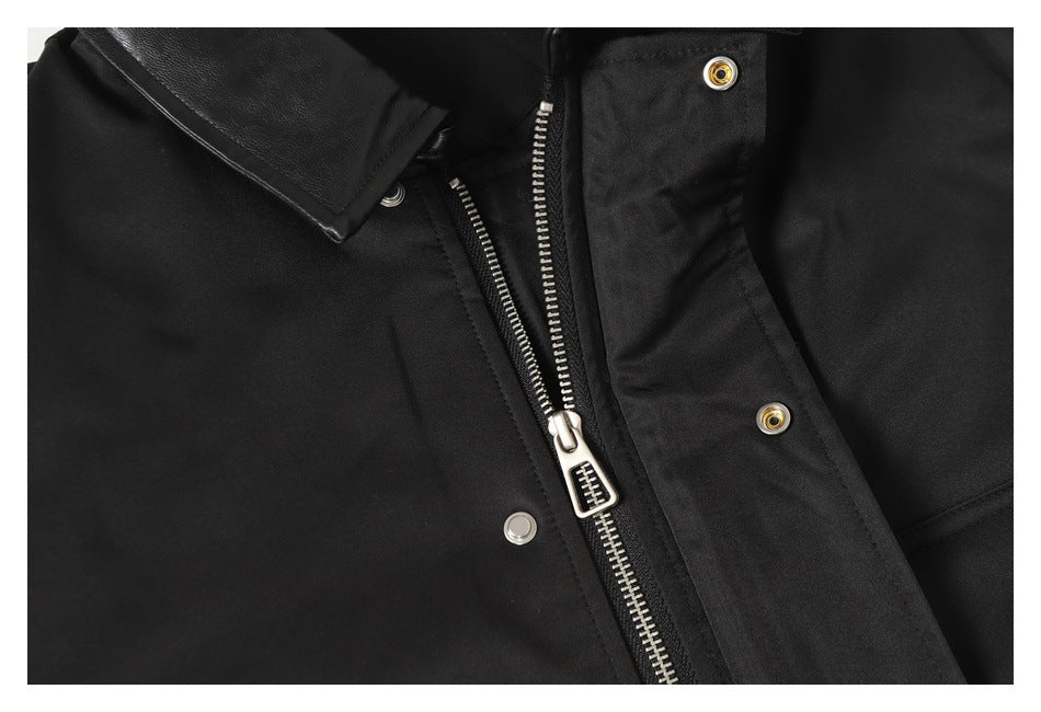 Close-up of the black jacket's front zipper, snap-button placket, and collar.