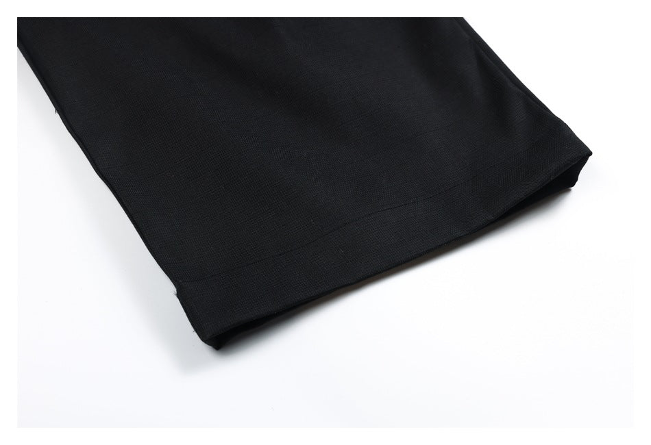 Close-up of black garment fabric and stitched hem against a white background.