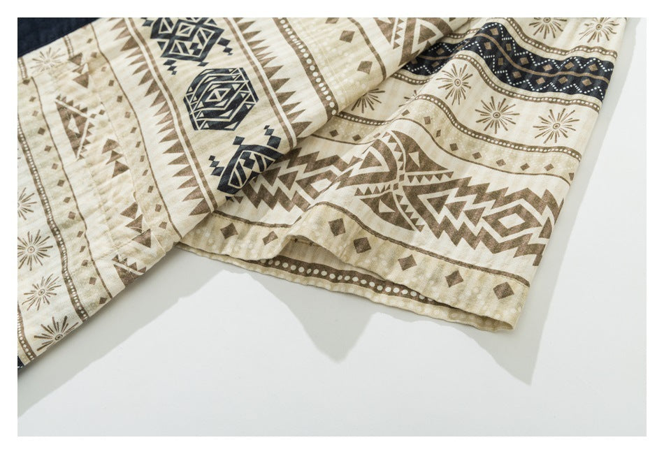 Close-up of the hem of a beige garment with brown and navy geometric patterns.