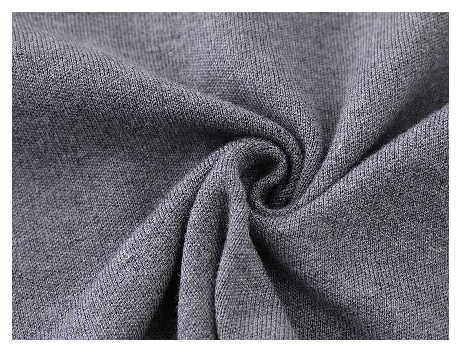 Close-up of gray knitted fabric gathered into folds, showing its fine textured stitch pattern.