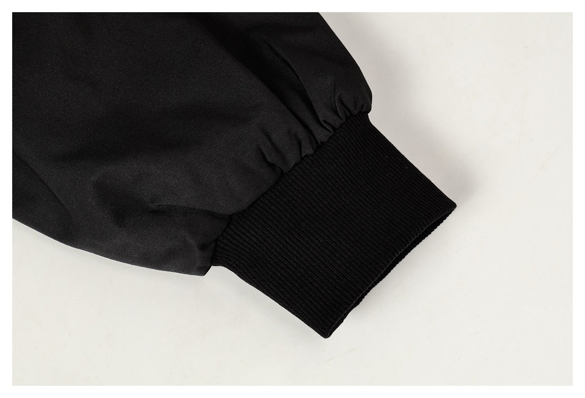 Close-up of a black jacket sleeve ending in a wide ribbed cuff.