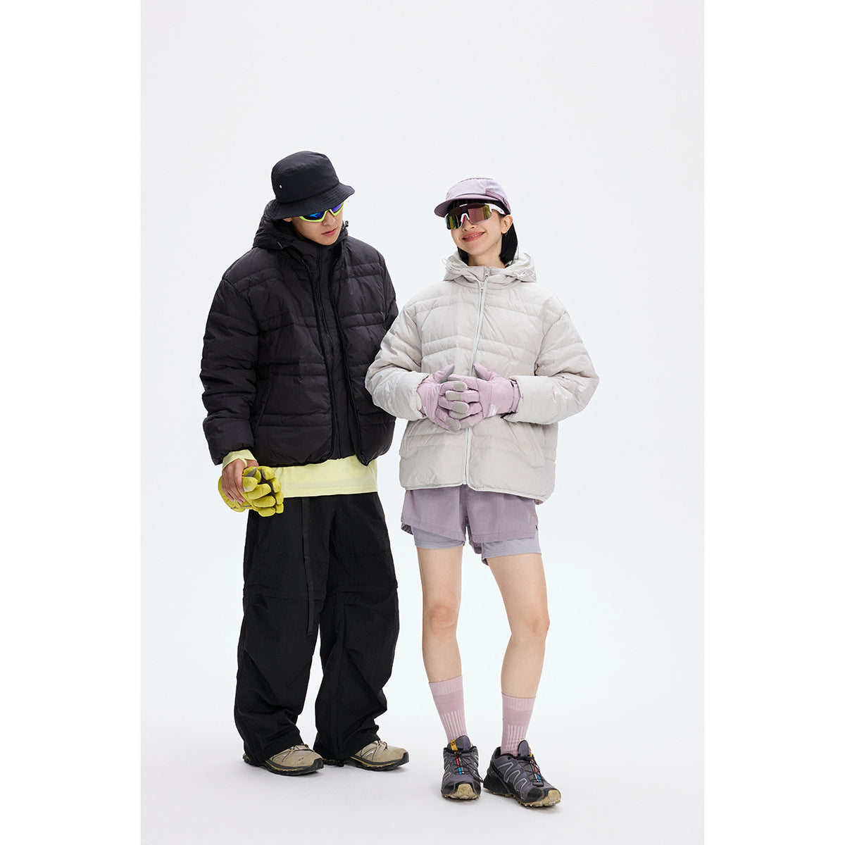 Two models wearing quilted jackets: one black and one off-white, styled with outdoor accessories.