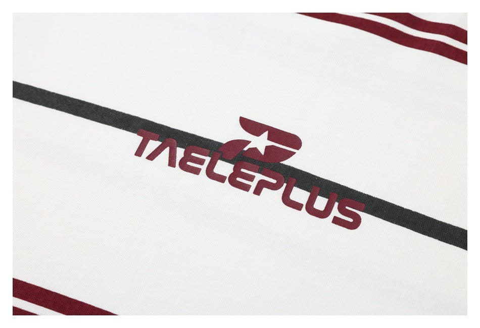 Close-up of white fabric with black and burgundy stripes and a burgundy printed wordmark.