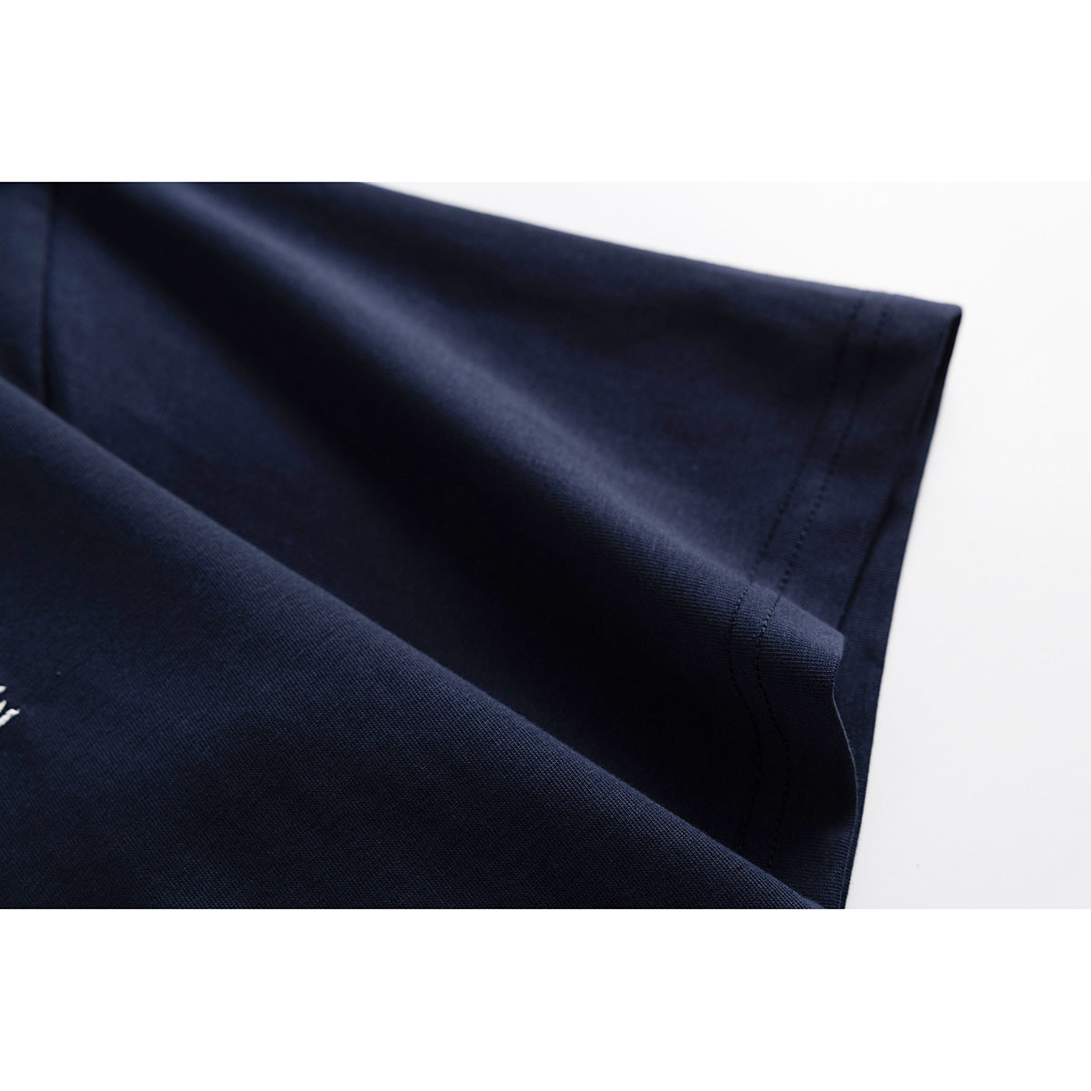 Close-up of a navy T-shirt sleeve and stitched hem.