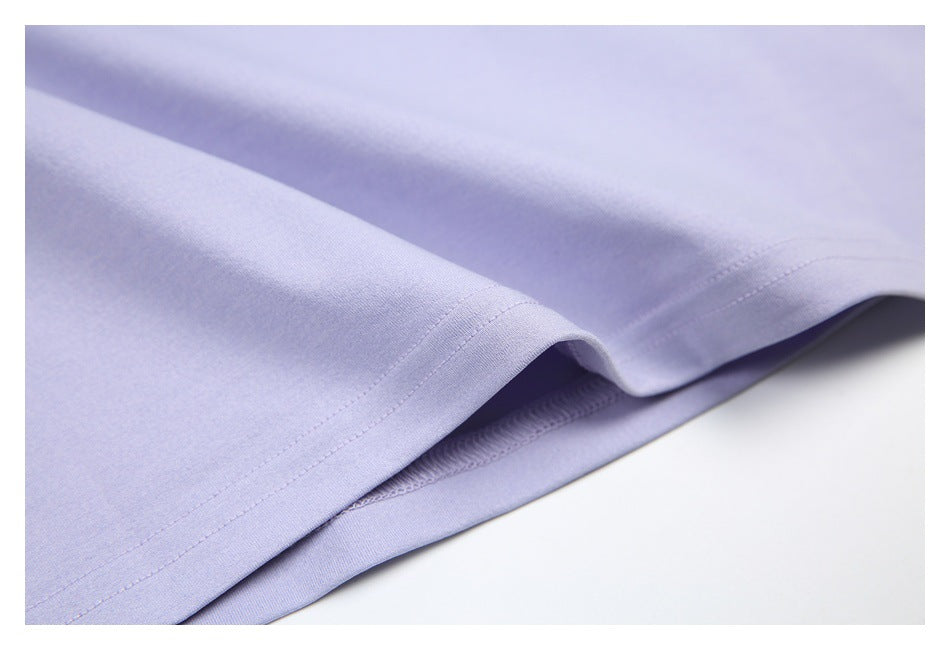 Close-up of a pale lavender garment hem with double stitching and the inside seam visible.