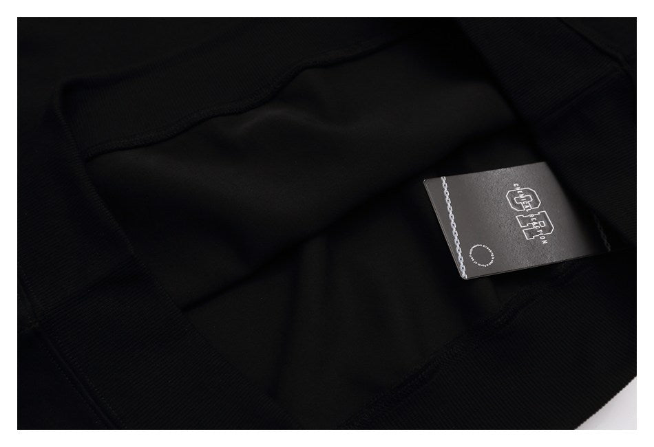Interior close-up of a black sweatshirt with a black branded hangtag.
