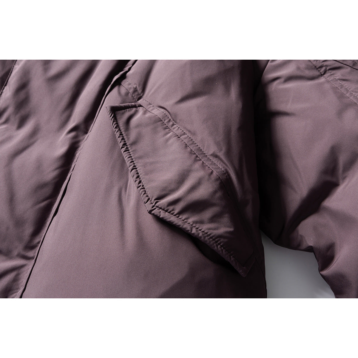 Close-up of a flap pocket on the mauve jacket.