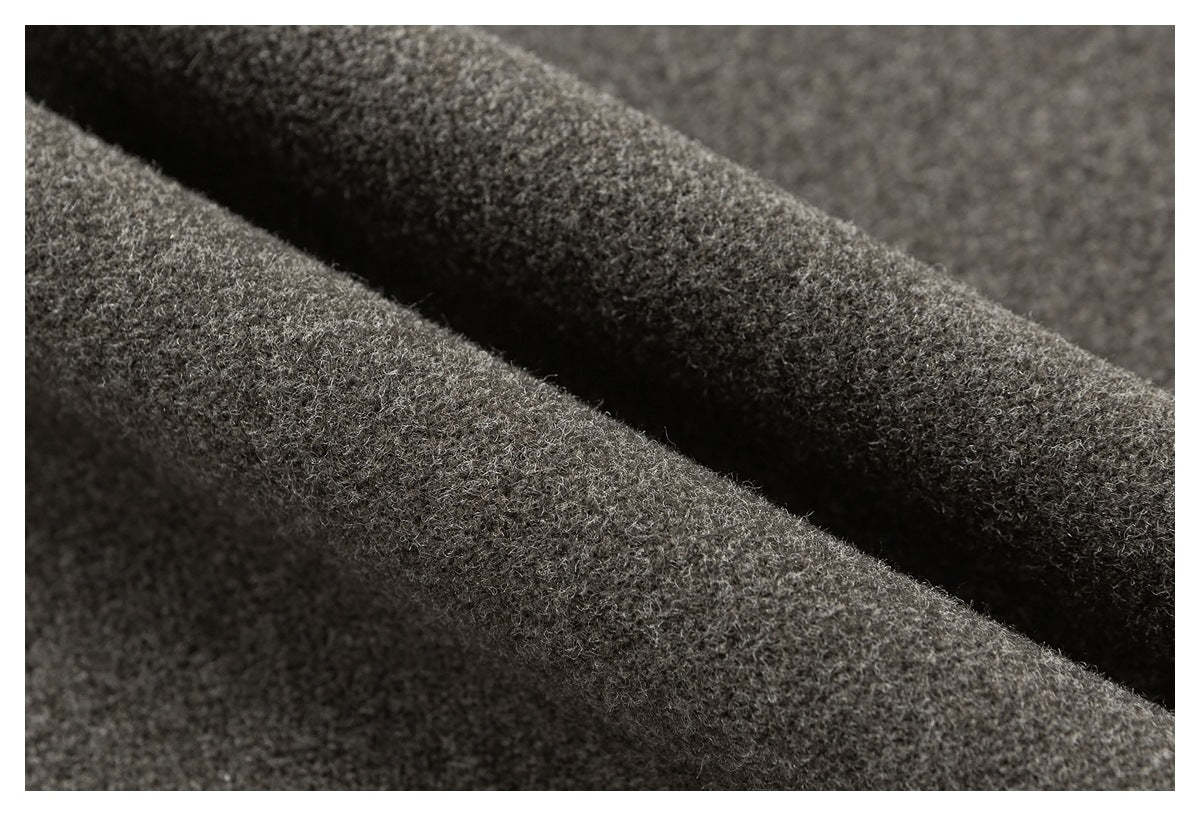 Macro view of gray-brown garment fabric folded into soft ridges.
