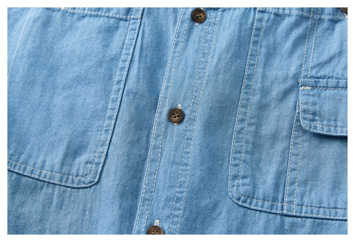 Close-up of a light blue shirt front with brown buttons, double stitching, and large patch pockets.