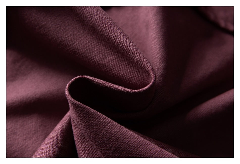 Close-up of burgundy fabric in soft folds, showing its fine textured weave.