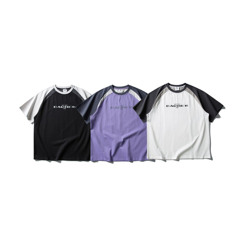 Three short-sleeve raglan T-shirts shown together in black and white, purple and gray, and white and charcoal.