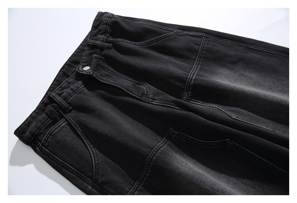 Angled close-up of black jeans showing the waistband, button, front pockets and contrast stitching.