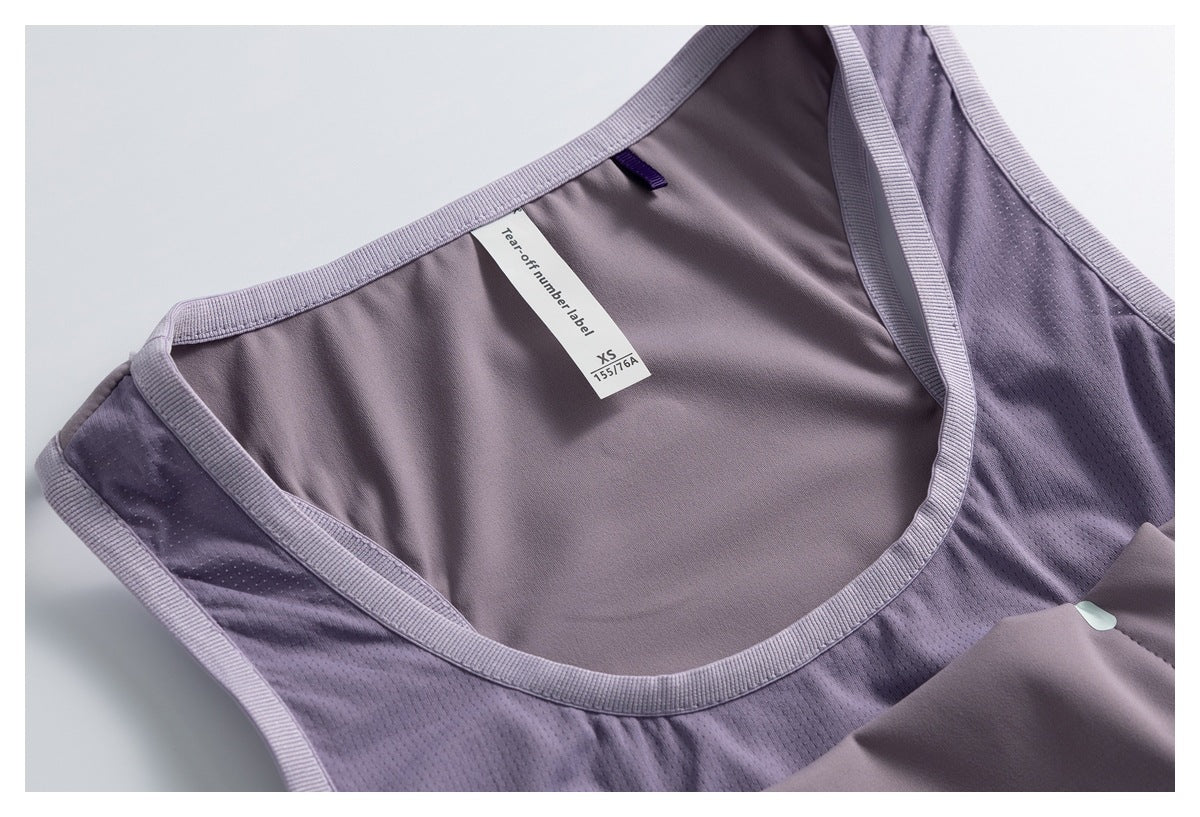 Close-up of a lavender athletic top's interior neckline and mesh panels, with a tear-off label marked XS and 155/76A.