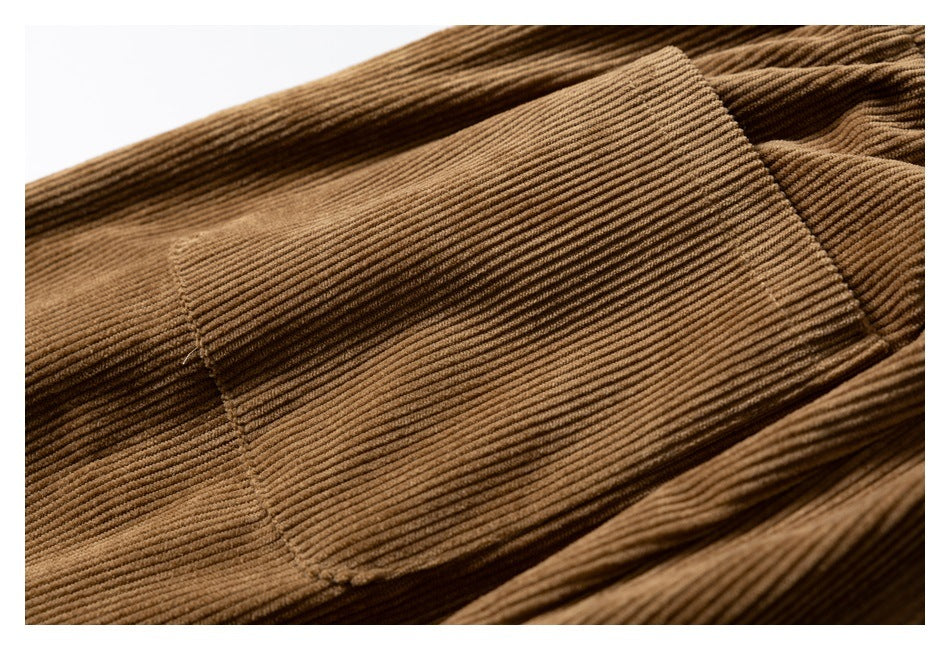 Close-up of a large rectangular patch pocket on brown corduroy pants.