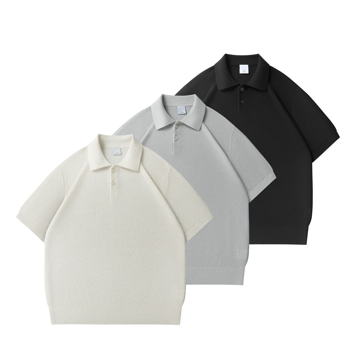 Three short-sleeve textured polo shirts arranged together in cream, light gray, and black.